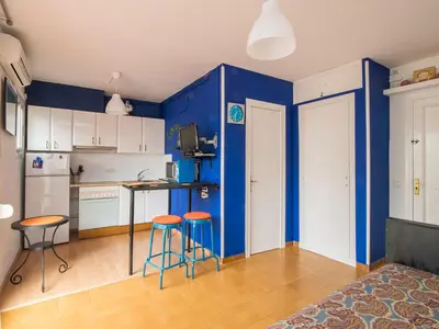 a kitchen with blue walls and stools in a room at Sunny Apartments in Sitges