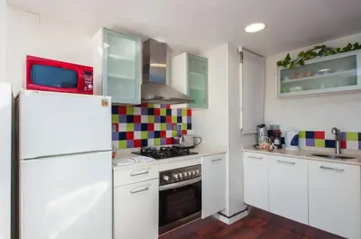 a kitchen with white cabinets and a white refrigerator at Sunny Apartments in Sitges