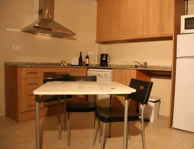 a kitchen with a table and chairs and a refrigerator at Apartments HHB in Barcelona
