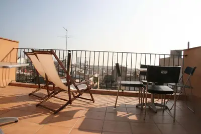 a balcony with chairs sitting on top of a building at Apartments HHB in Barcelona