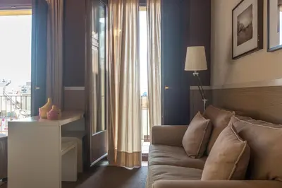 a living room with a couch and a large window at Apartments HHB in Barcelona