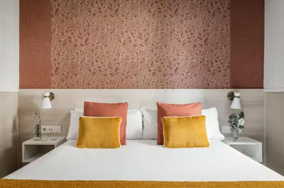a bedroom with a white bed with two yellow pillows at BYPILLOW House in Barcelona