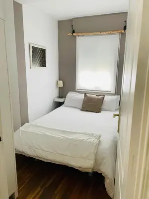 a bedroom with a white bed and a window at Sweet Atic in Sitges