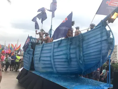 a group of people on a blue boat in a parade at Sweet Atic in Sitges