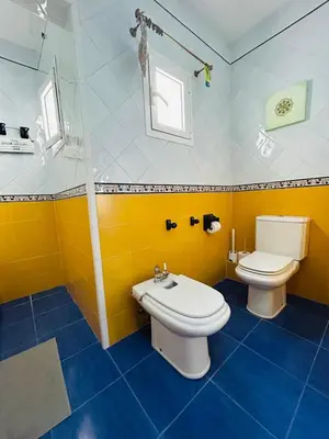a yellow bathroom with a toilet and a sink at Sweet Atic in Sitges