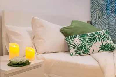 a couch with pillows and two candles on a table at Stay U-nique Apartments Provença in Barcelona