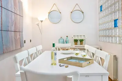 a white dining room with a white table and white chairs at Stay U-nique Apartments Provença in Barcelona