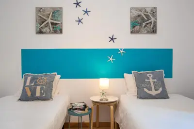 two beds in a room with a blue headboard at Stay U-nique Apartments Sicília in Barcelona