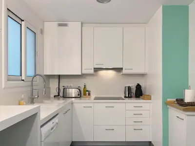 a white kitchen with white cabinets and a sink at Stay U-nique Apartments Roger Llúria in Barcelona