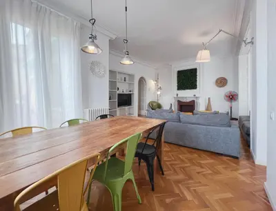 a kitchen and living room with a wooden table and chairs at Stay U-nique Apartments Roger Llúria in Barcelona