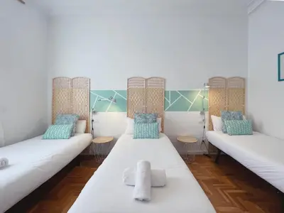a room with three beds with blue and white pillows at Stay U-nique Apartments Roger Llúria in Barcelona