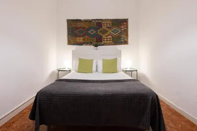 a bedroom with a large bed with two green pillows at Stay U-nique Apartments Casanova in Barcelona