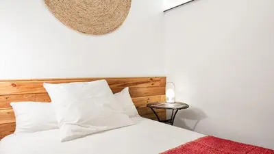 a bedroom with a white bed with a wooden headboard at Brummell Apartments Eixample Izquierda/Valeris in Barcelona