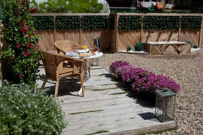 a garden with a table and chairs and purple flowers at BacHome Terrace B&B in Barcelona
