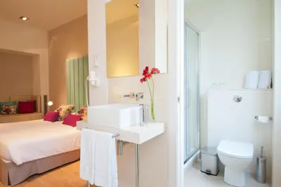 a bathroom with a sink and a toilet and a bed at BacHome Terrace B&B in Barcelona
