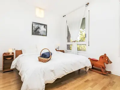 a white bedroom with a bed and a window at Apartment Vila Olimpica Sant Marti by Interhome in Barcelona