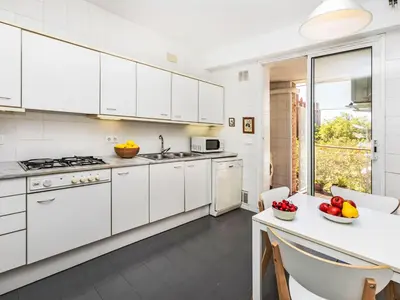 a kitchen with white cabinets and a table with fruit on it at Apartment Vila Olimpica Sant Marti by Interhome in Barcelona