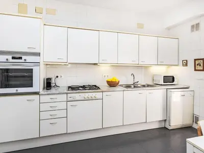 a white kitchen with white cabinets and appliances at Apartment Vila Olimpica Sant Marti by Interhome in Barcelona