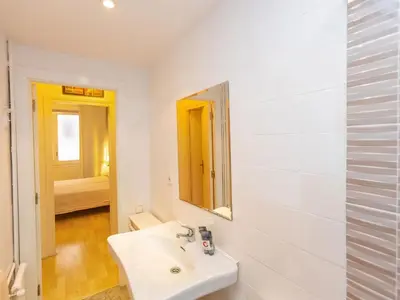 a white bathroom with a sink and a mirror at Apartment Eixample Dret Corsega Roger Lluria by Interhome in Barcelona
