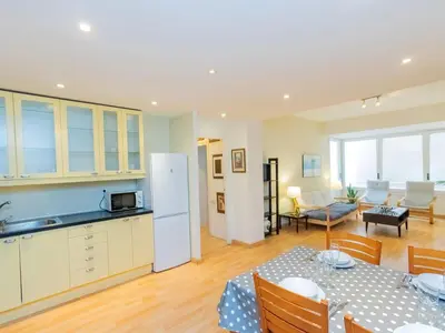a kitchen and living room with a table and a refrigerator at Apartment Eixample Dret Corsega Roger Lluria by Interhome in Barcelona