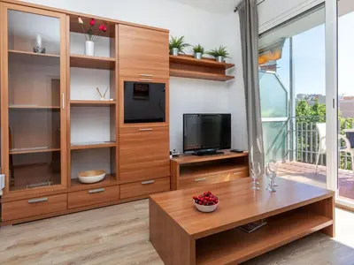 a living room with a tv and a wooden entertainment center at Apartment Eixample Esq Rocafort Diputacio by Interhome in Barcelona
