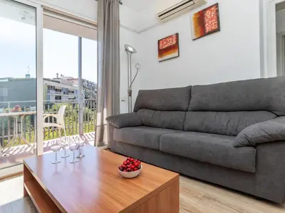 a living room with a couch and a table with wine glasses at Apartment Eixample Esq Rocafort Diputacio by Interhome in Barcelona