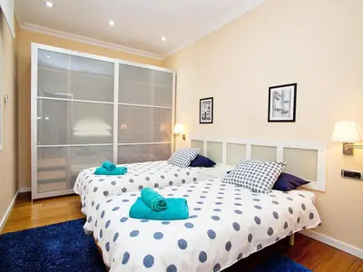 two beds in a bedroom with two blue towels at Apartment Eixample Esquerre Gran Via Balmes by Interhome in Barcelona