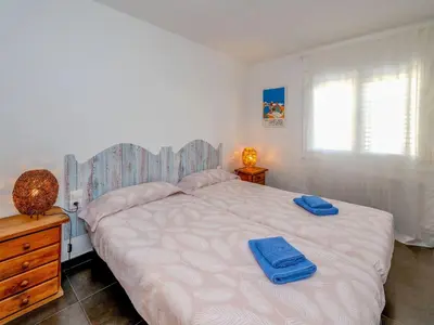 a bedroom with a large bed with blue towels on it at Apartment Blaumar by Interhome in Sant Andreu de Llavaneres