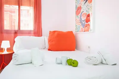 a white bed with towels and apples on it at Stay U-nique Apartments Ricart in Barcelona