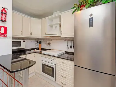 a kitchen with white cabinets and a stainless steel refrigerator at Apartment Aires de mar by Interhome in Cunit