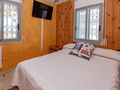 a bedroom with a white bed with two windows at Apartment Aires de mar by Interhome in Cunit