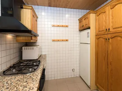 a kitchen with a stove and a white refrigerator at Apartment Eixample Esquerre Arago Rocafort by Interhome in Barcelona