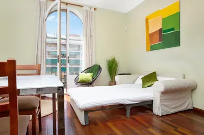 a bedroom with a bed and a table and a window at Stay U-nique Apartments Provença II in Barcelona
