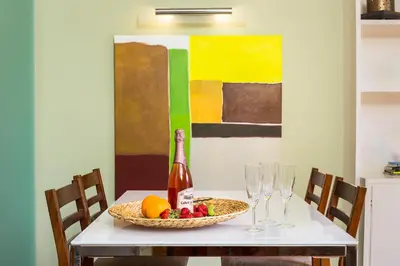a table with a bottle of wine and a bowl of fruit at Stay U-nique Apartments Provença II in Barcelona
