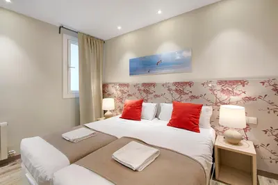 a bedroom with two beds with red pillows at Eixample Building Apartments by Mercedes Heritage in Barcelona