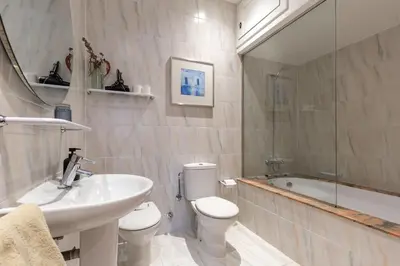 a bathroom with a sink and a toilet and a tub at Alos Apartments Paseo de Gracia-Diagonal in Barcelona