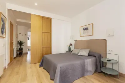 a bedroom with a bed and a wooden floor at Alos Apartments Paseo de Gracia-Diagonal in Barcelona