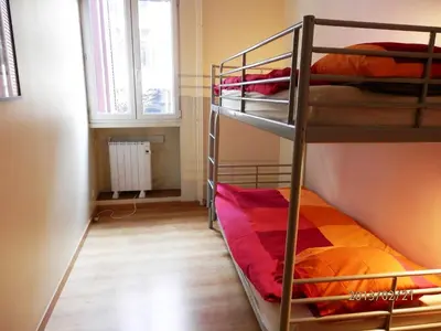 two bunk beds in a small room with a window at Barcelona Central Garden Hostal in Barcelona