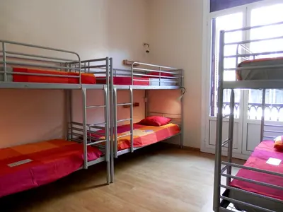 two bunk beds in a room with a window at Barcelona Central Garden Hostal in Barcelona