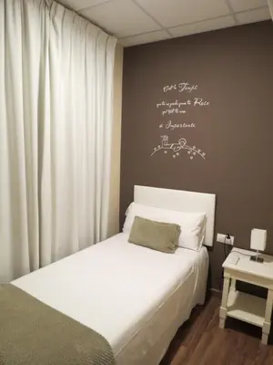 a bedroom with a bed and a wall with writing on it at Hostal Petit Príncep in Barcelona