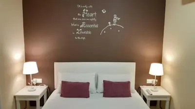 a bedroom with a bed with two tables and two lamps at Hostal Petit Príncep in Barcelona