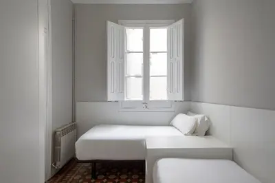 a white room with two beds and a window at Barcelona Apartment Val in Barcelona