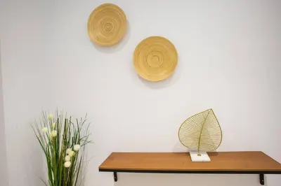 a table with a fan and a vase of flowers on a wall at Stay U-nique Apartments Fabra i Puig in Barcelona