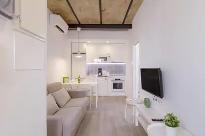a living room with a couch and a kitchen at Ola Living Camp Nou in Hospitalet de Llobregat