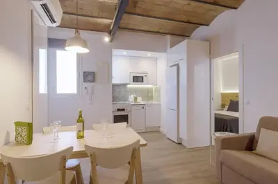 a kitchen and living room with a table and chairs at Ola Living Camp Nou in Hospitalet de Llobregat