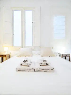a bedroom with a white bed with towels on it at BCN Apartments 41 in Barcelona