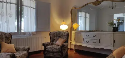 a living room with two chairs and a mirror at Mas Cabrit in Les Franqueses del Vallès