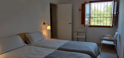 a bedroom with a bed and a window and a chair at Mas Cabrit in Les Franqueses del Vallès