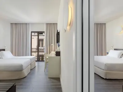 a hotel room with two beds and a desk at H10 Port Vell 4* Sup in Barcelona