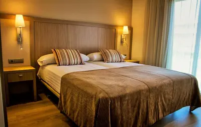 a hotel room with a large bed and a window at Apartaments Maritim in Castelldefels